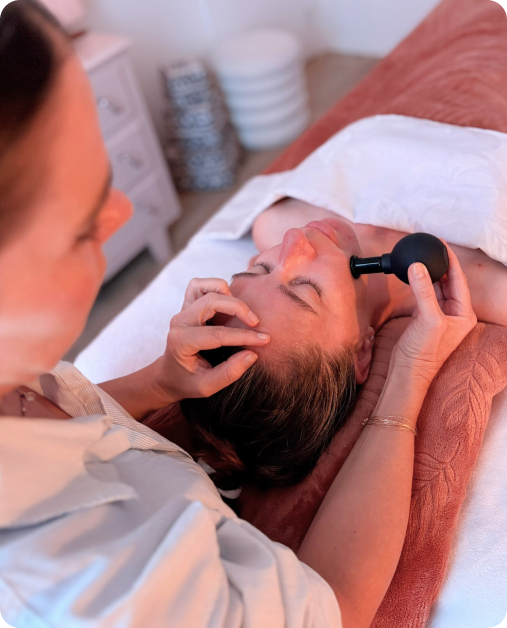 Esthéticienne indépendante réalisant un soin du visage dans sa cabine